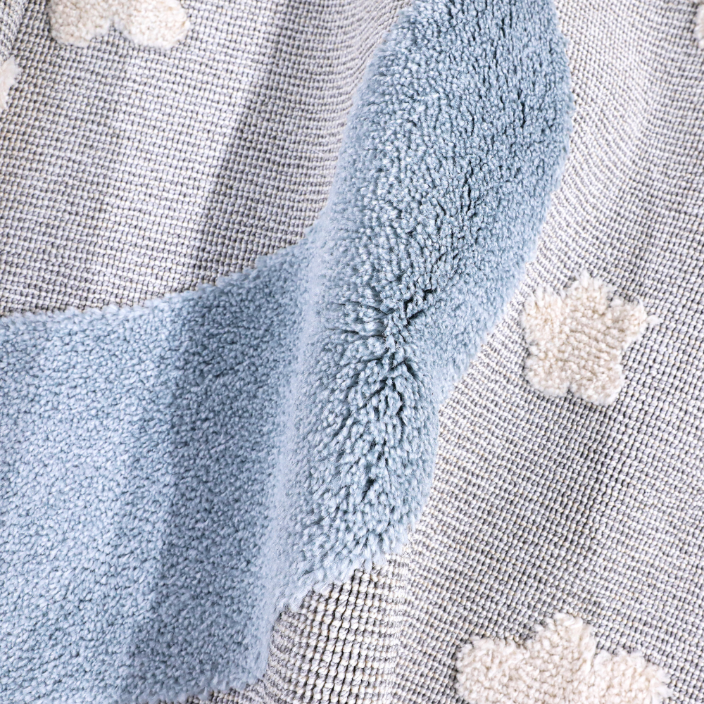 Soft kids woven rug with crescent moon and star designs in soothing blue and gray.