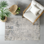 Nash abstract textured rug in gray and blue under a chair with plant decor