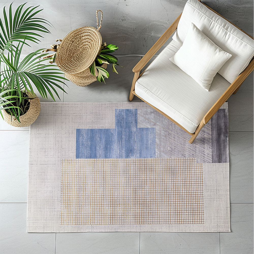 Geometric Ivy modern rug in blue and yellow under a chair with a plant.