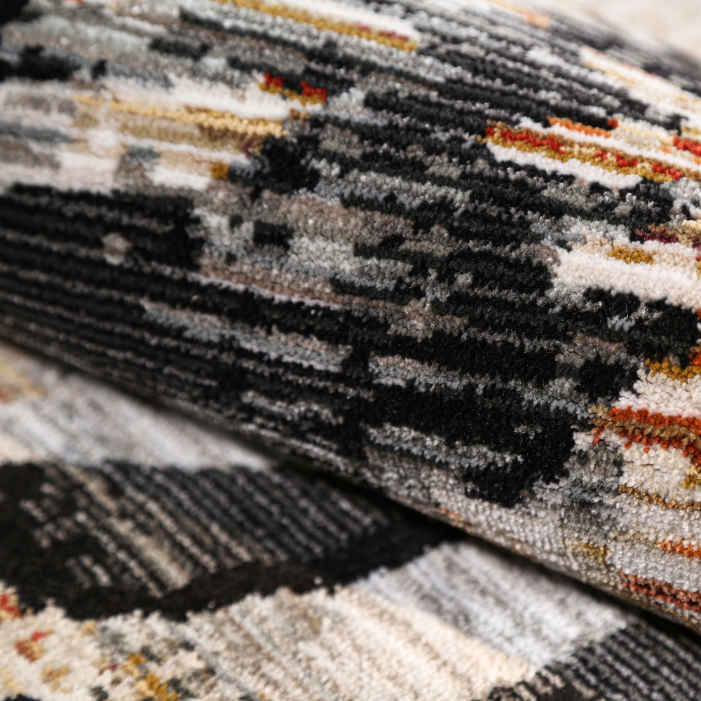 Textured lily rug in black, white, and orange with intricate design.