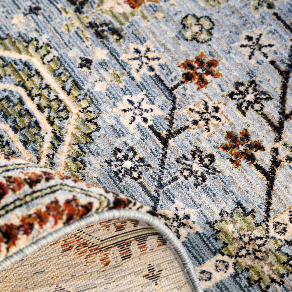 Textured blue rug with floral and geometric designs, perfect for home decor.