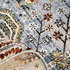 Textured blue rug with floral and geometric designs, perfect for home decor.