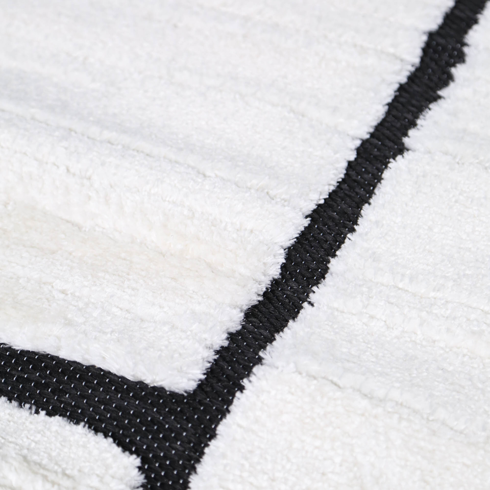 Eldrin geometric textured rug close-up in cream and black colors